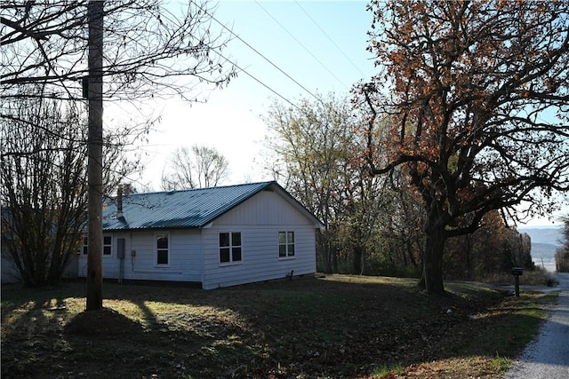 view of home's exterior with metal roof and a lawn