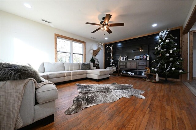 living room featuring ceiling fan and dark hardwood / wood-style floors