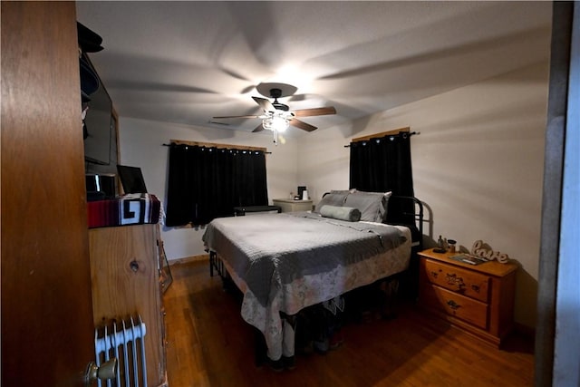 bedroom with dark hardwood / wood-style floors and ceiling fan