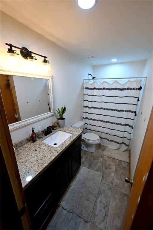 bathroom featuring a shower with curtain, vanity, and toilet