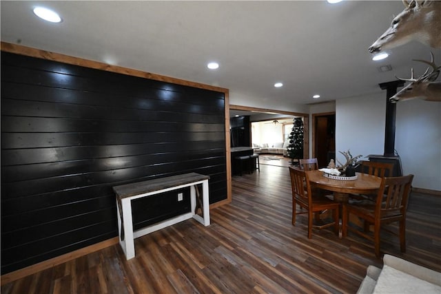 dining room with dark hardwood / wood-style floors and a wood stove