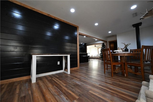 dining space with wooden walls and dark hardwood / wood-style floors