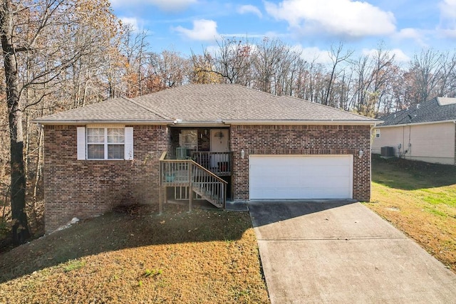 ranch-style home featuring a front lawn, central AC unit, and a garage