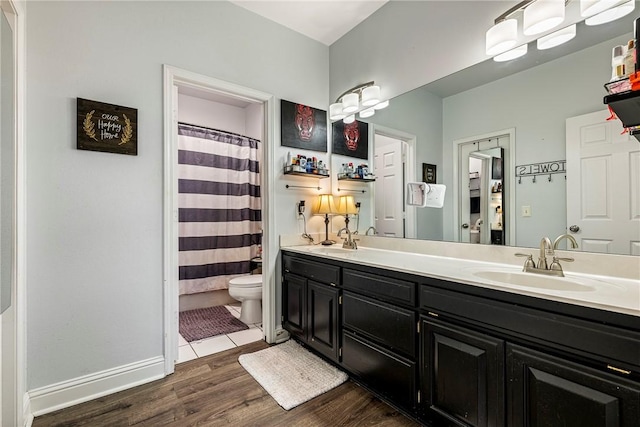 bathroom featuring a shower with shower curtain, vanity, wood-type flooring, and toilet