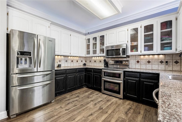 kitchen featuring stainless steel appliances, white cabinetry, crown molding, and light hardwood / wood-style flooring