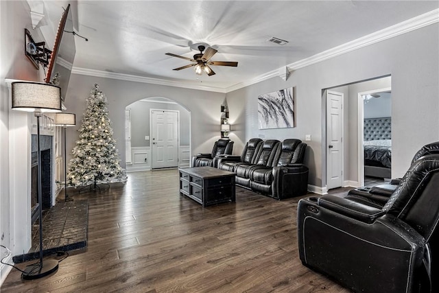 living room with crown molding, a fireplace, ceiling fan, and dark hardwood / wood-style floors