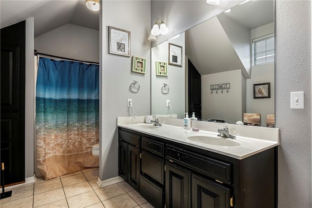 bathroom featuring tile patterned flooring, vanity, toilet, and lofted ceiling