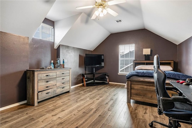 bedroom with ceiling fan, vaulted ceiling, and hardwood / wood-style flooring