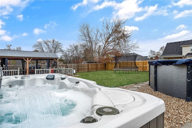 view of yard with a gazebo, a trampoline, and a hot tub