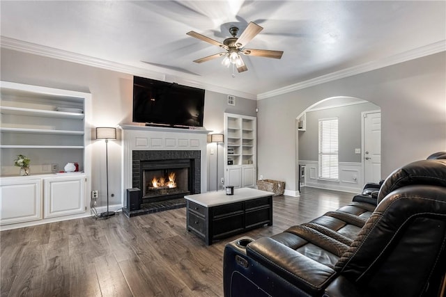 1007 N Quail Ter, Rogers, AR 72756 - living room with arched walkways, a ceiling fan, wood finished floors, a brick fireplace, and crown molding