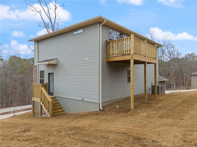 back of house featuring central AC and a balcony