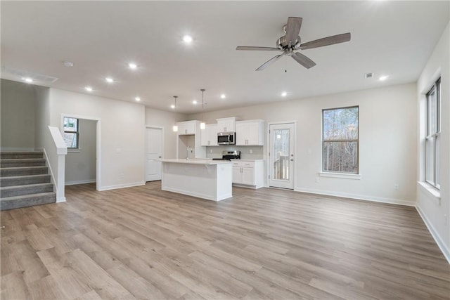 unfurnished living room featuring light hardwood / wood-style floors and ceiling fan