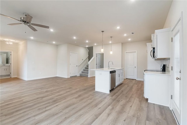 kitchen featuring pendant lighting, appliances with stainless steel finishes, an island with sink, and white cabinets