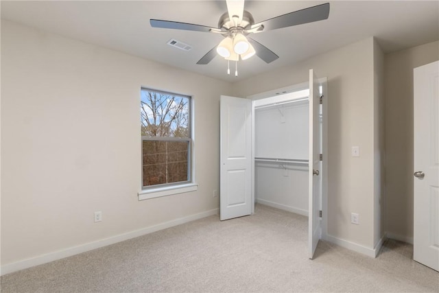 unfurnished bedroom with light colored carpet, ceiling fan, and a closet