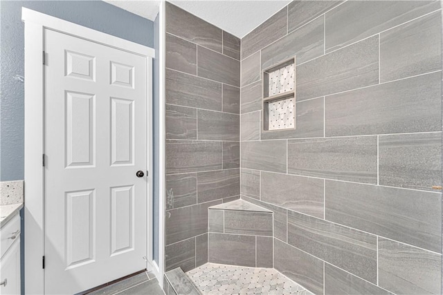 bathroom featuring vanity and tiled shower