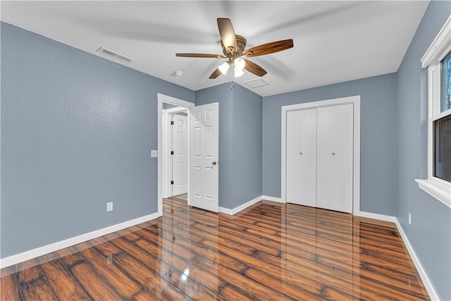 bedroom featuring dark hardwood / wood-style flooring, ceiling fan, and a closet