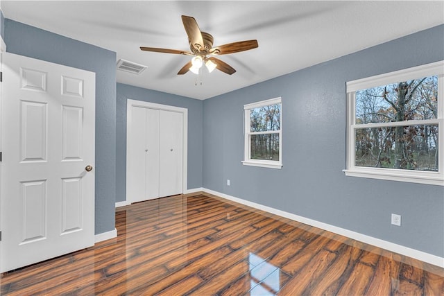 unfurnished bedroom with a closet, ceiling fan, and dark hardwood / wood-style flooring