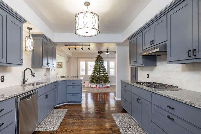 kitchen with appliances with stainless steel finishes, dark hardwood / wood-style flooring, hanging light fixtures, and sink