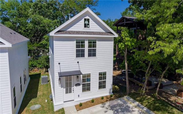 back of property with a lawn and cooling unit