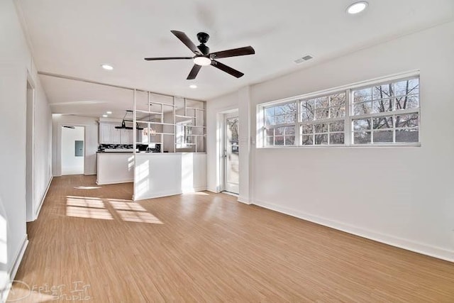 unfurnished living room with ceiling fan and light hardwood / wood-style floors