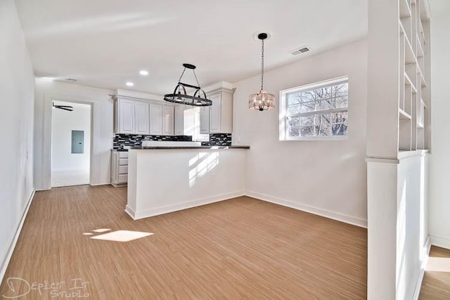 kitchen featuring white cabinets, tasteful backsplash, and light hardwood / wood-style flooring