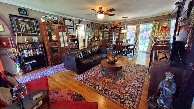 living room featuring ceiling fan, crown molding, and light hardwood / wood-style flooring