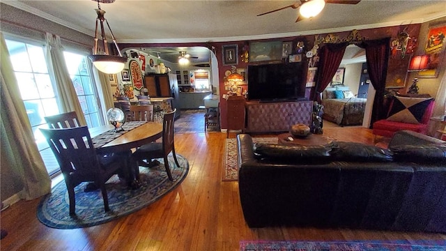 living room featuring hardwood / wood-style floors, a textured ceiling, and crown molding