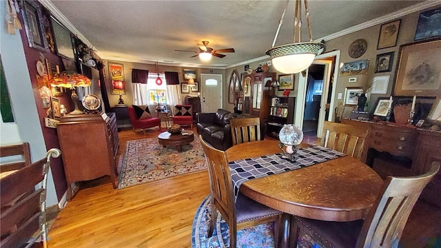 dining room with light hardwood / wood-style floors, ceiling fan, and crown molding