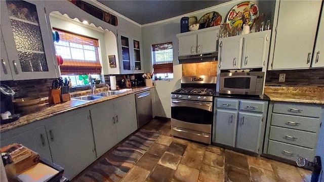 kitchen featuring decorative backsplash, ornamental molding, sink, and appliances with stainless steel finishes