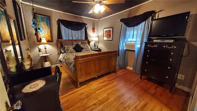 bedroom featuring hardwood / wood-style flooring, ceiling fan, and ornamental molding