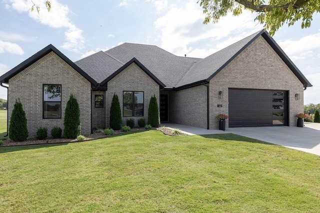 french provincial home featuring a front yard and a garage