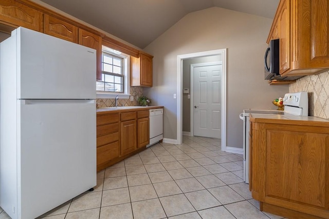 kitchen with light tile patterned floors, white appliances, vaulted ceiling, and backsplash