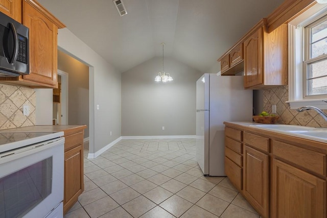 kitchen featuring backsplash, sink, a chandelier, and white appliances