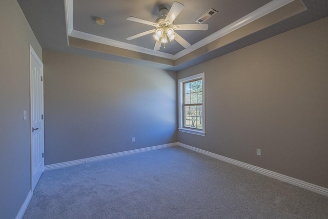 empty room with carpet floors, crown molding, and a tray ceiling