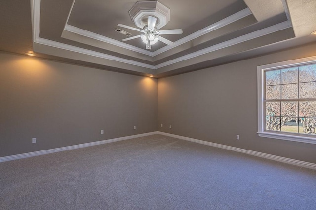 carpeted spare room with ceiling fan, crown molding, and a tray ceiling