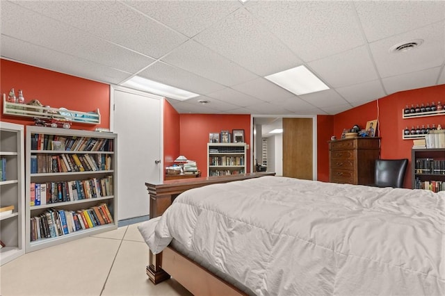 bedroom featuring a drop ceiling and tile patterned flooring