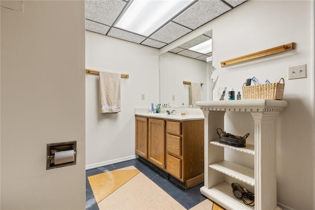 bathroom featuring vanity and a drop ceiling