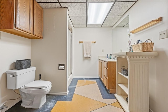 bathroom featuring vanity, tile patterned floors, a paneled ceiling, and toilet