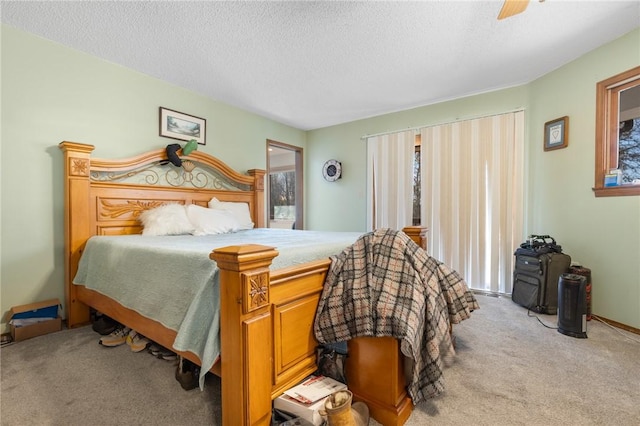 bedroom featuring a textured ceiling, ceiling fan, and light carpet