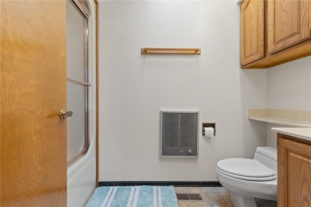 full bathroom with vanity, combined bath / shower with glass door, tile patterned flooring, toilet, and heating unit