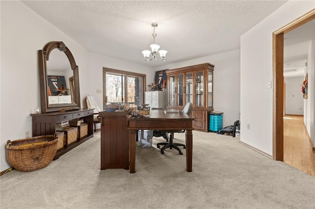 office with a textured ceiling, light colored carpet, and an inviting chandelier