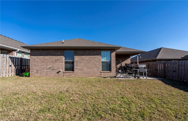 back of house featuring a lawn and a patio area