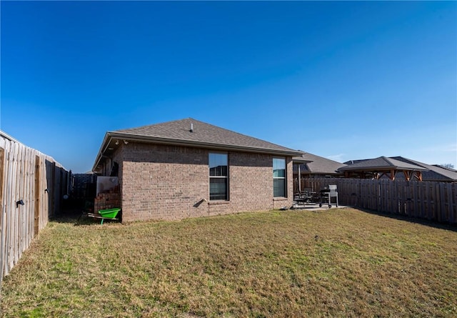 back of house featuring a lawn and a patio area