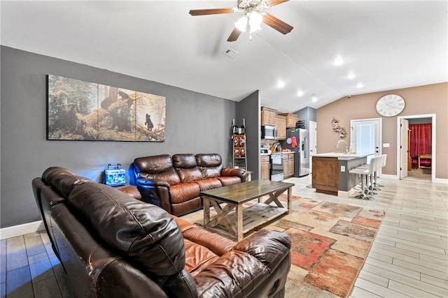 living room with ceiling fan, light hardwood / wood-style floors, and vaulted ceiling