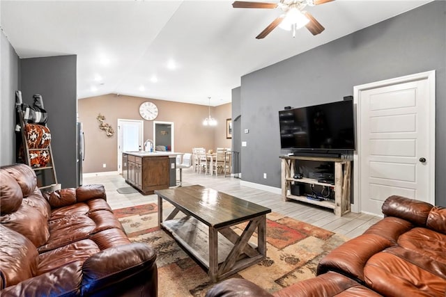 living room featuring ceiling fan with notable chandelier, light wood-type flooring, lofted ceiling, and sink