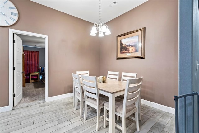 dining room with light hardwood / wood-style floors and a notable chandelier