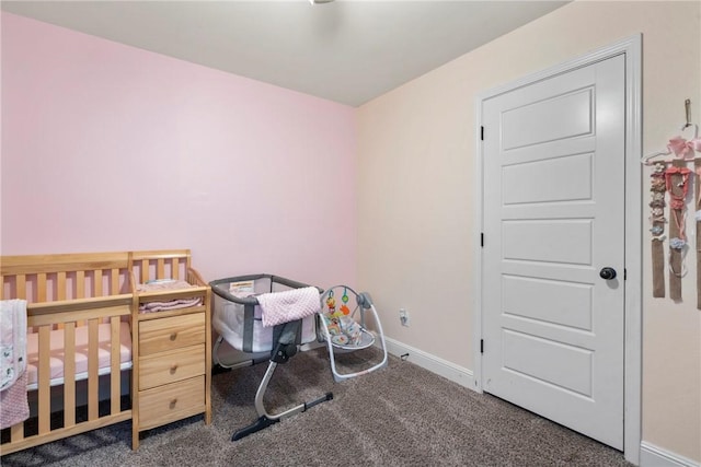 bedroom with dark carpet and a nursery area