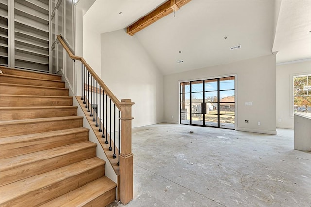 unfurnished living room featuring beam ceiling and high vaulted ceiling