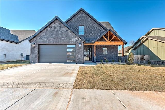 view of front facade with central AC unit, a garage, covered porch, and a front lawn