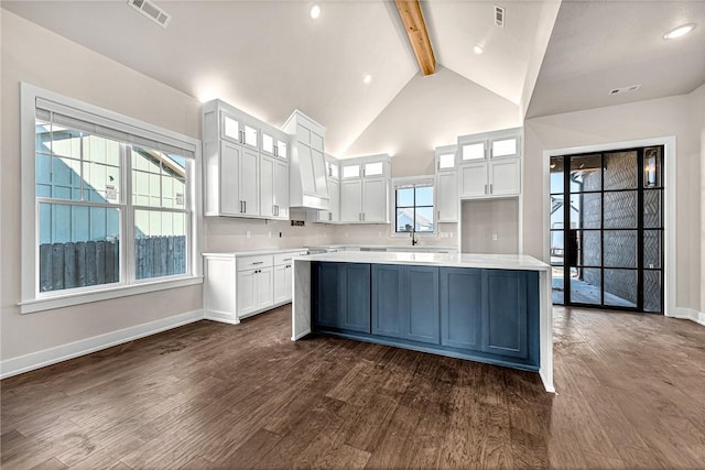 kitchen with white cabinets, dark hardwood / wood-style flooring, and beamed ceiling